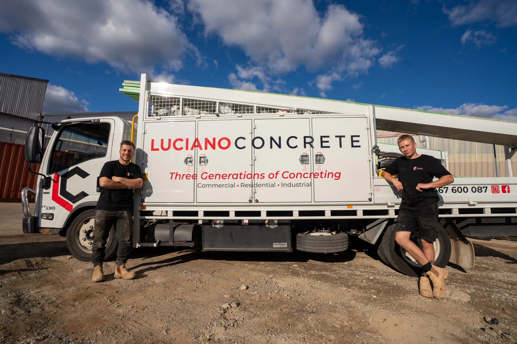Team members posing in front of a Luciano Concrete truck.